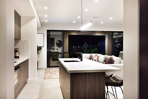 Modern kitchen countertop closeup with a view of patio area from the outside at night